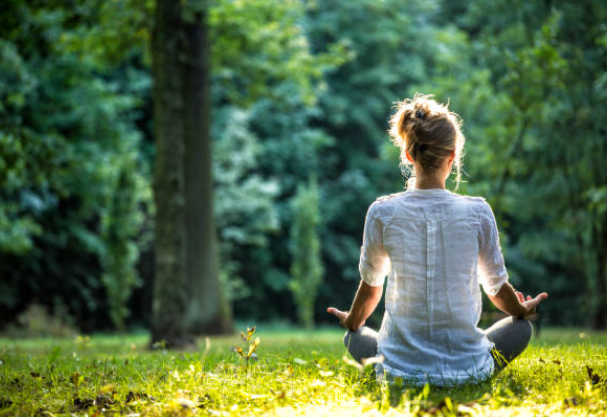 Image of woman sitting in a yoga pose and practicing mindful ness 